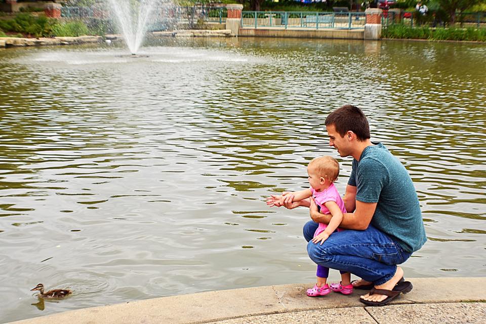 Dad with daughter looking at a duck